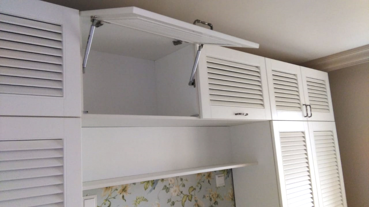 Стильная светлая кухня с белыми жалюзийными фасадами на верхних шкафах